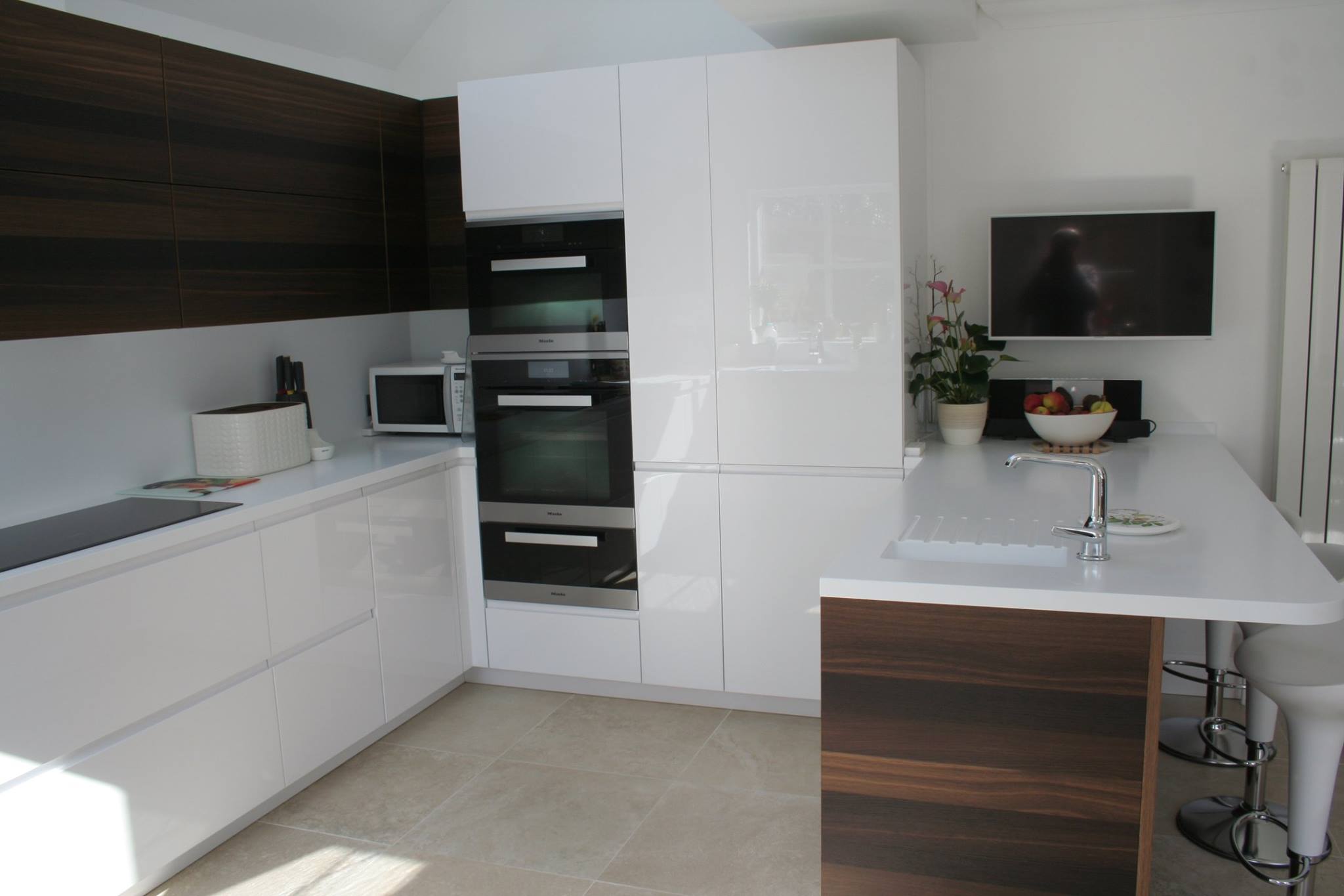 Solo in high gloss white, with smoked oak — a Rational kitchen by Kitchensmiths, with corian worktops (photograph 3 of 3)