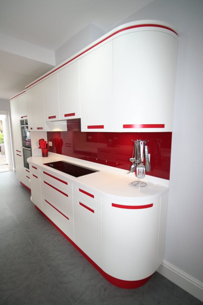 Red stripes and curves, 1950s futurism — a Stoneham kitchen by Kitchensmiths, with corian worktops (photograph 1 of 3)