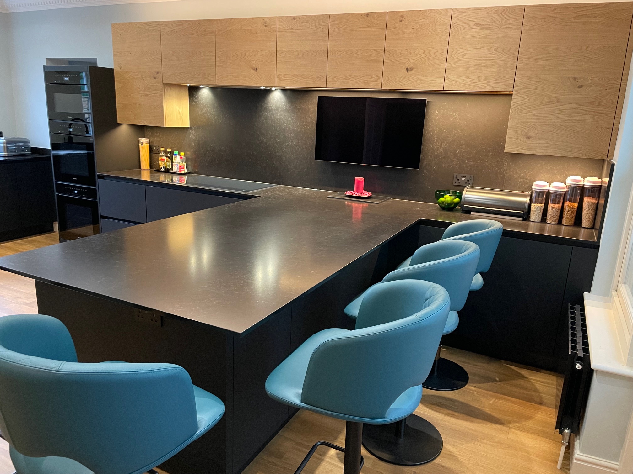 Fenix black and bookmatched oak — a Sachsenküchen kitchen by Kitchensmiths, with quartz worktops (photograph 3 of 5)