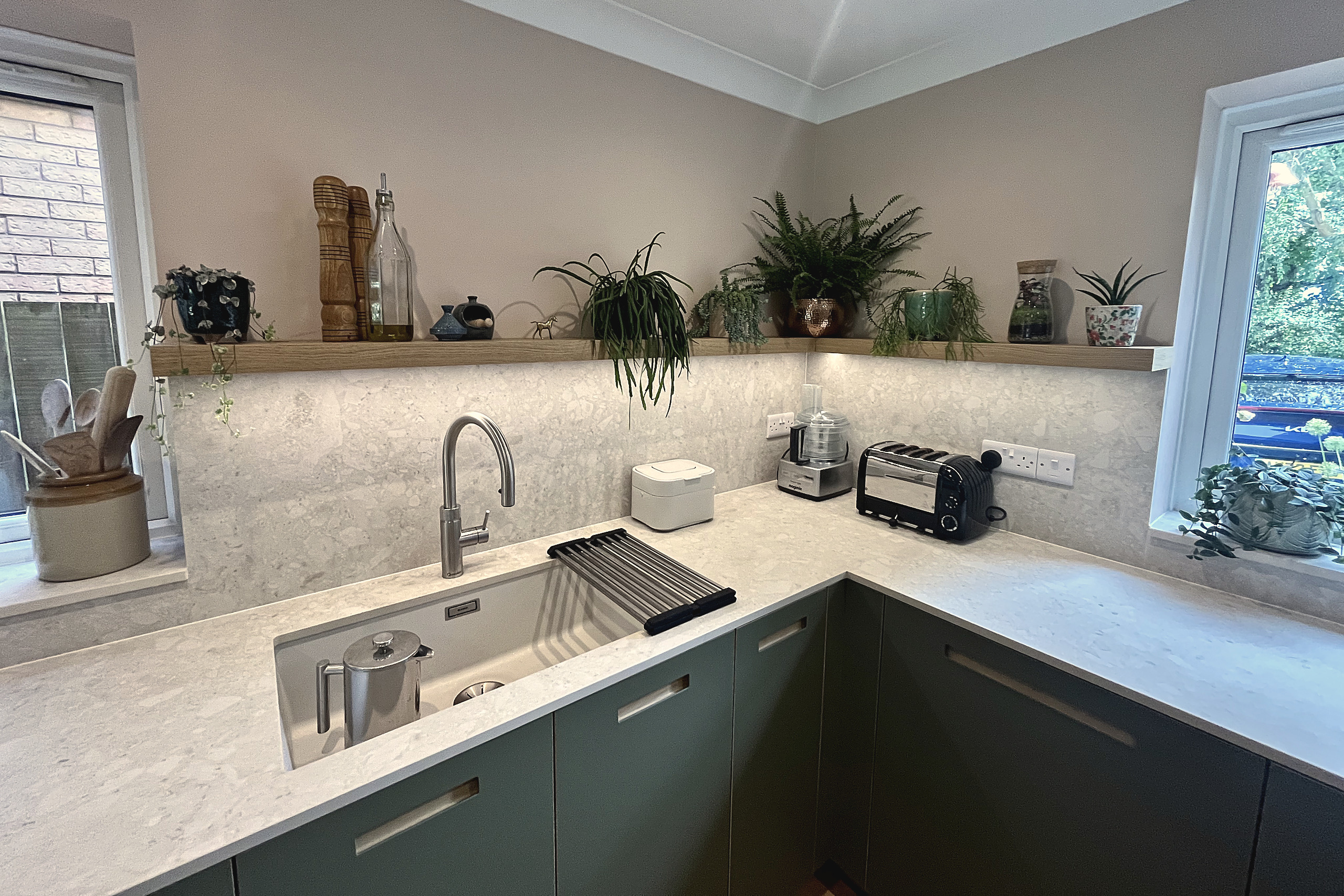 Brushed steel tap and inset sink in quartz worktop with oak shelf and stone splashback
