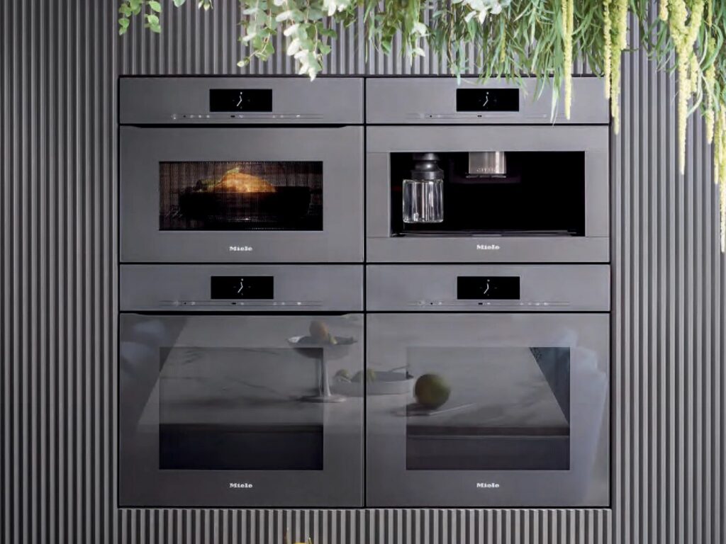 Appliances — a bank of four integrated Miele ovens and a coffee machine