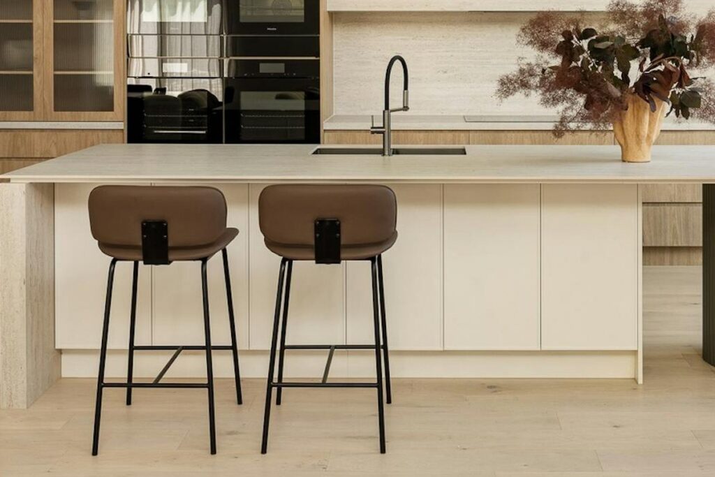 A pale Silestone quartz island worktop with an integrated sink, against oak cabinetry