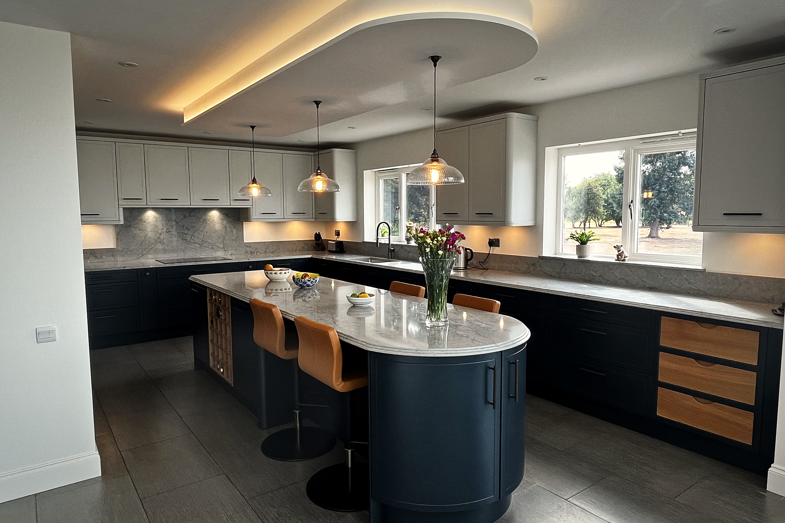 Open-plan kitchen with Railings painted island, Dove Grey wall units and Cristallo Platino quartz worktops