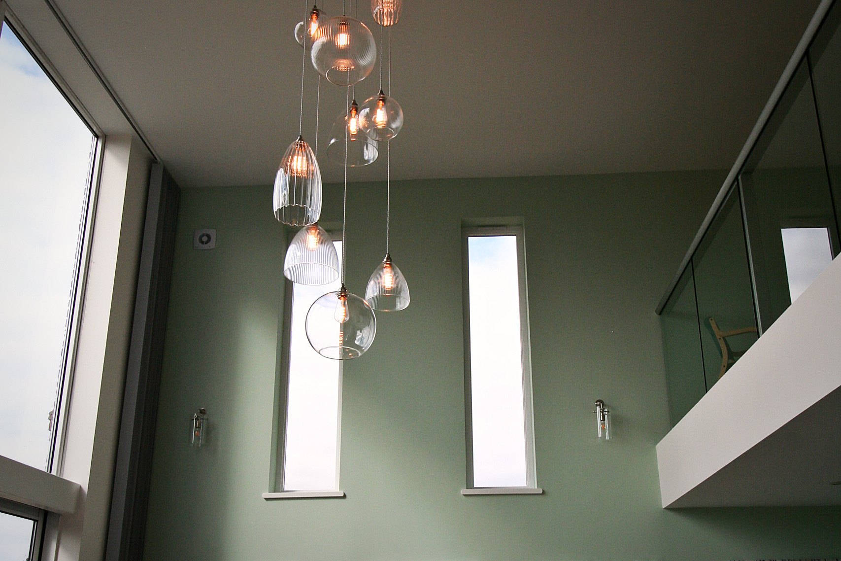 Fritz Fryer multi-drop glass chandelier suspended above a seating area in a double-height living room