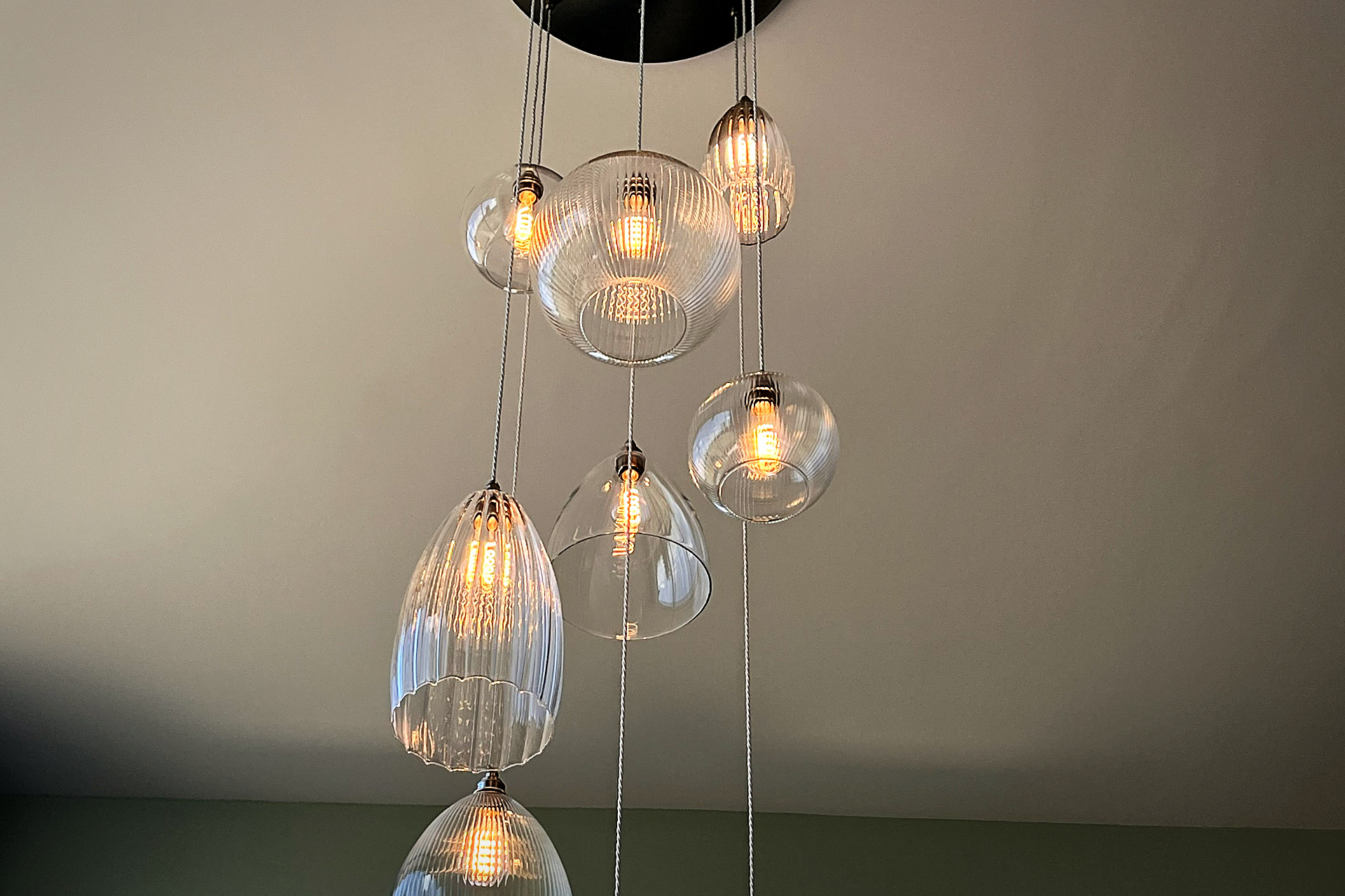 Fritz Fryer multi-drop glass chandelier hanging in a double-height space with tall windows